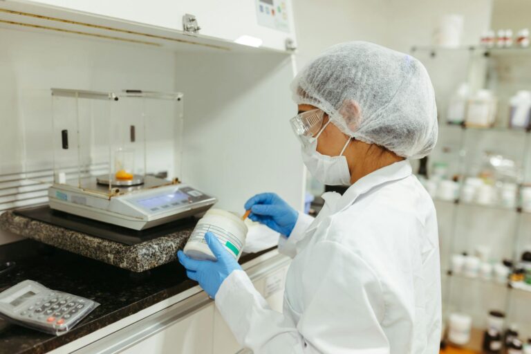A scientist in a lab coat conducts an experiment in a laboratory, showcasing precision and safety protocols.