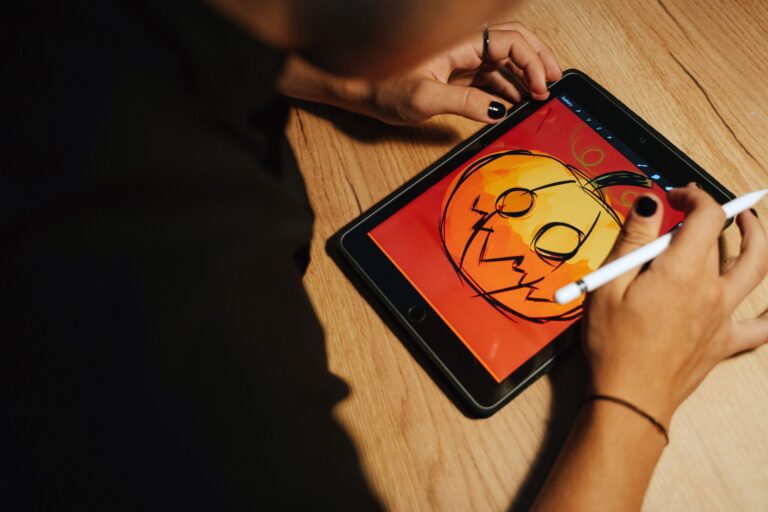 Creating a Halloween pumpkin illustration on a tablet with a stylus.