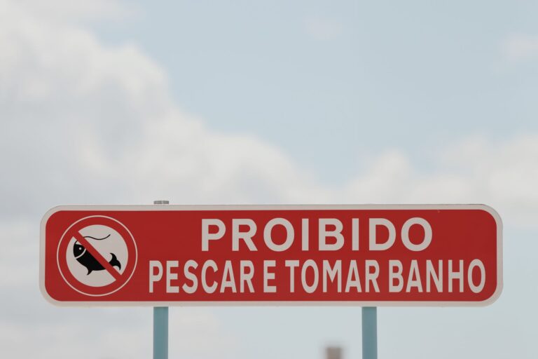 Red prohibition sign in Lisbon, Portugal forbidding fishing and bathing.