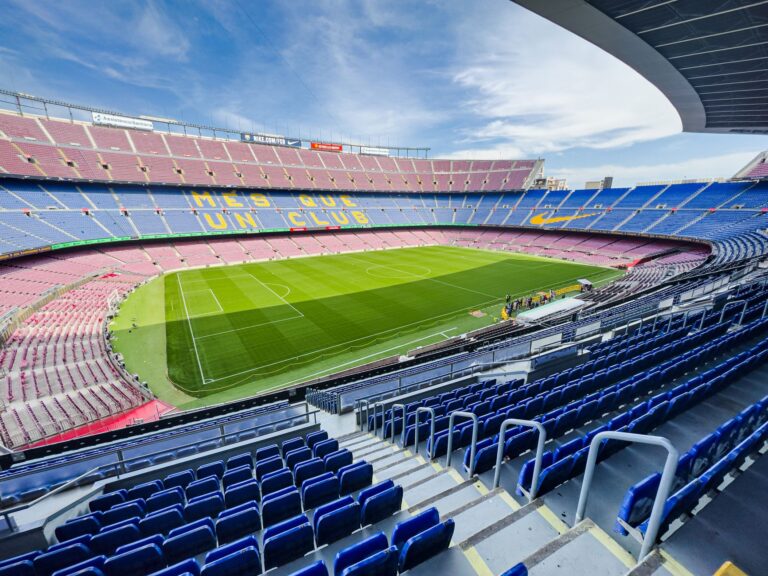 Wide-angle view of the iconic Camp Nou stadium in Barcelona, Spain, featuring its vibrant seating and green field.