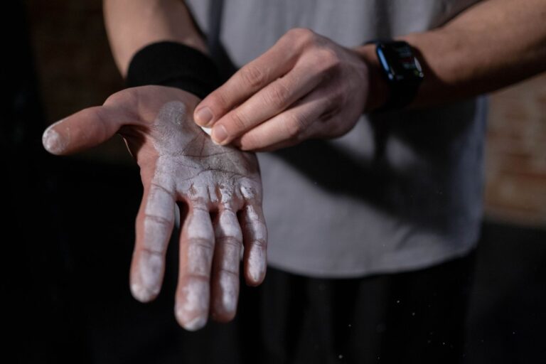 A detailed view of a hand applying gym chalk indoors, symbolizing fitness and preparation.