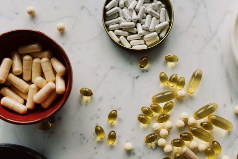 From above of biologically active additives and pills during sorting in different containers on the table in the hospital