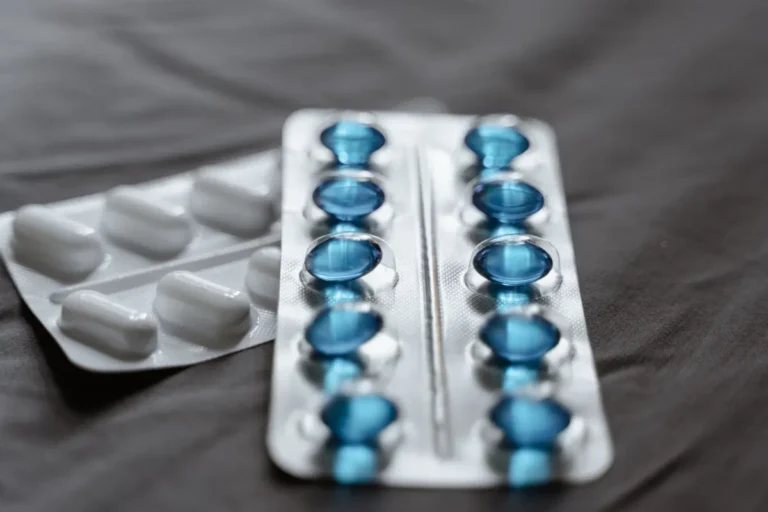 Detailed view of medication in blister packs showcasing blue softgel capsules and white pills.